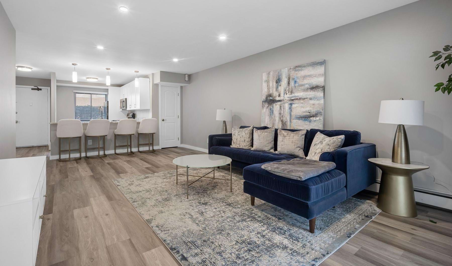 a living room with a blue couch and a wood floor