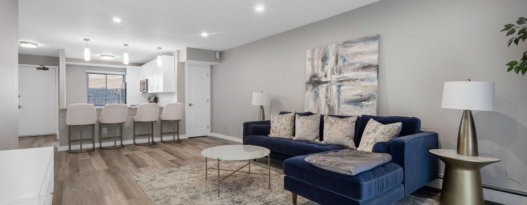 a living room with a blue couch and a wood floor